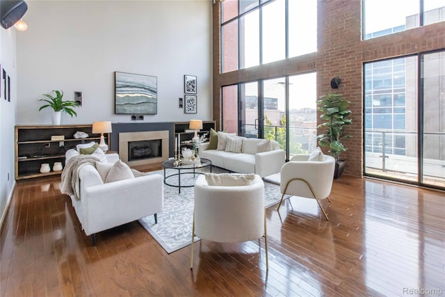 100 N Center St Unit 302, Royal Oak, MI 48067 - living area featuring wood-type flooring, a towering ceiling, and a fireplace