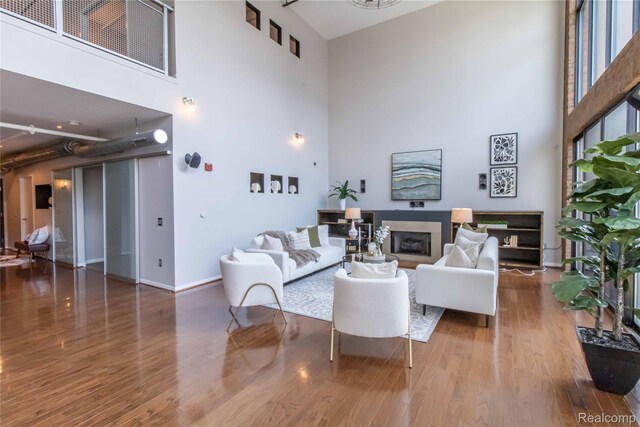 100 N Center St Unit 302, Royal Oak, MI 48067 - living area featuring a towering ceiling, wood finished floors, and a fireplace