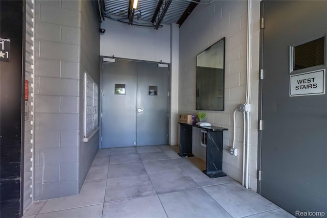 100 N Center St Unit 302, Royal Oak, MI 48067 - hall featuring concrete block wall and a high ceiling