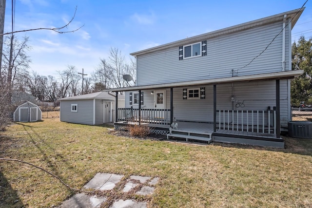 back of property featuring a yard, a shed, central AC, and an outdoor structure