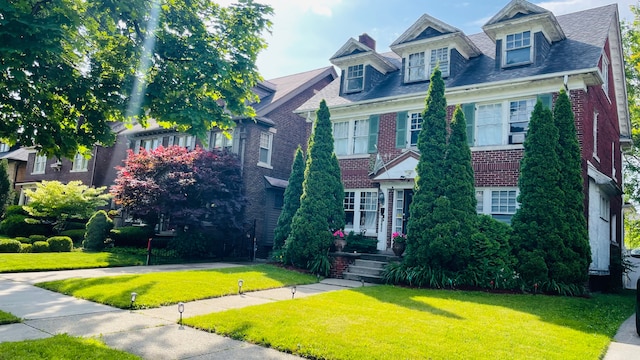view of front of house with a front yard and brick siding