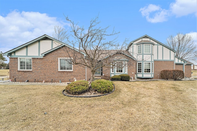 tudor house with brick siding and a front lawn