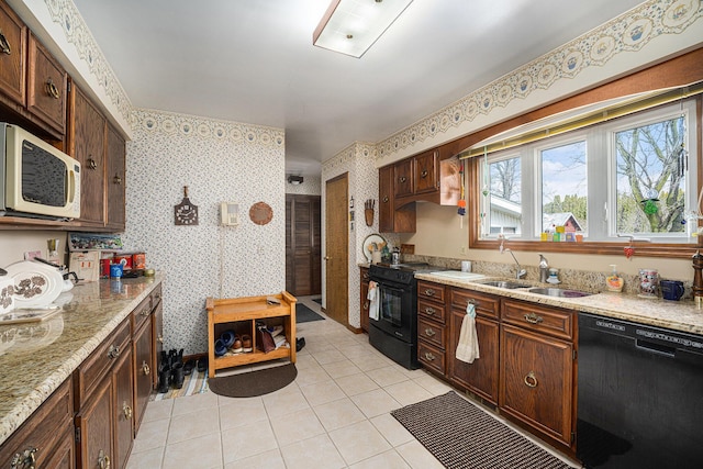 kitchen with light tile patterned flooring, wallpapered walls, and black appliances