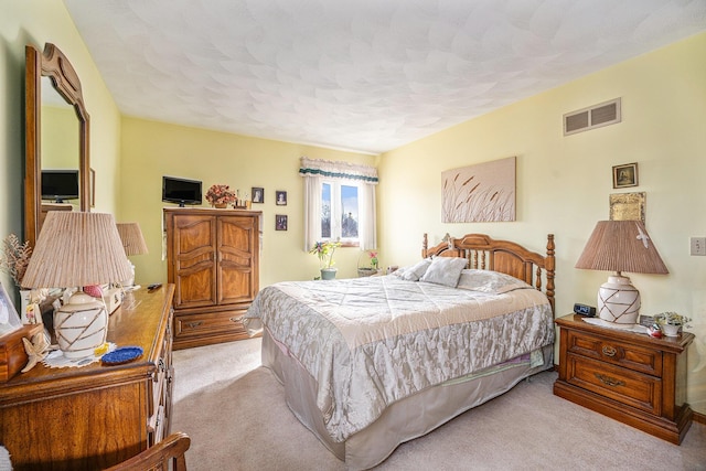 bedroom with visible vents, carpet flooring, and a textured ceiling