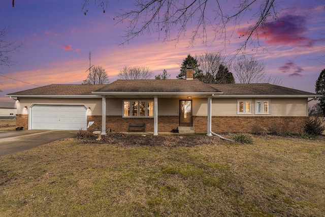 ranch-style home with concrete driveway, a front yard, an attached garage, brick siding, and a chimney