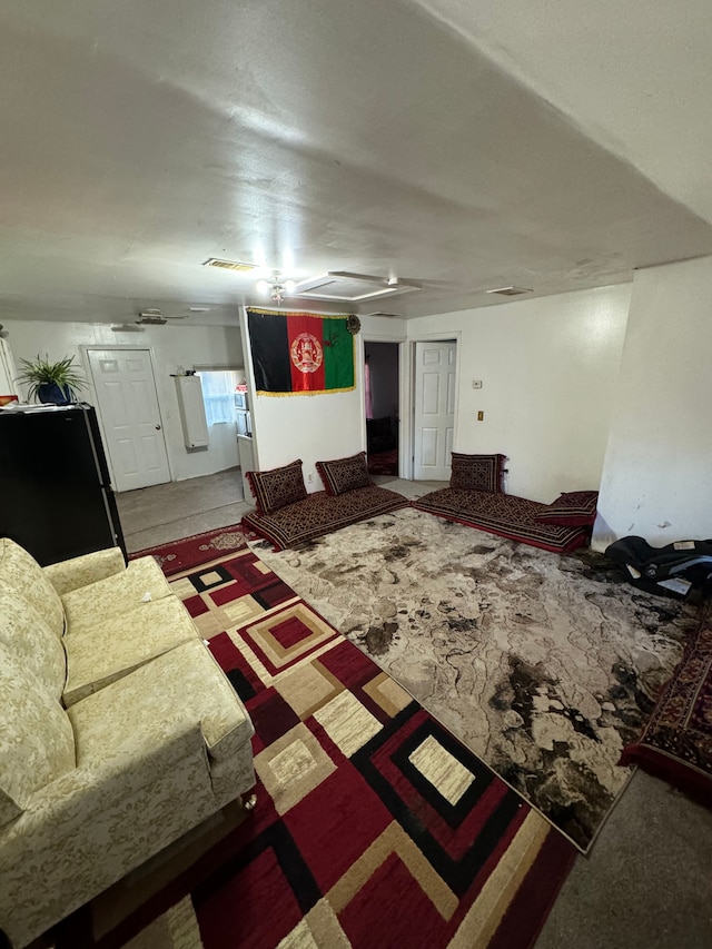 living room featuring visible vents, attic access, and ceiling fan