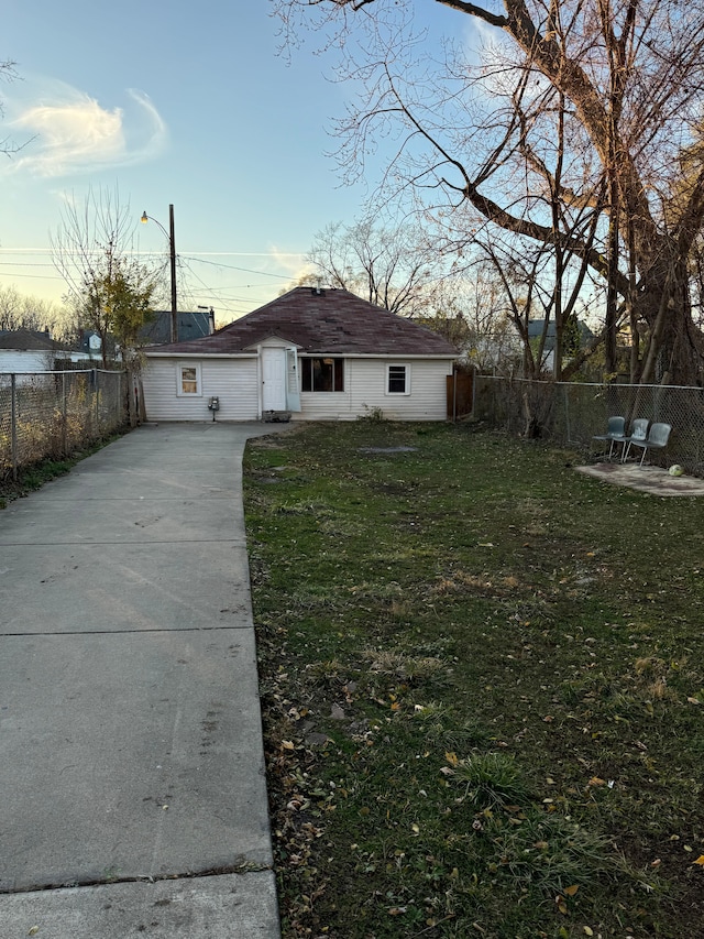 view of front of house with concrete driveway, a front lawn, and fence