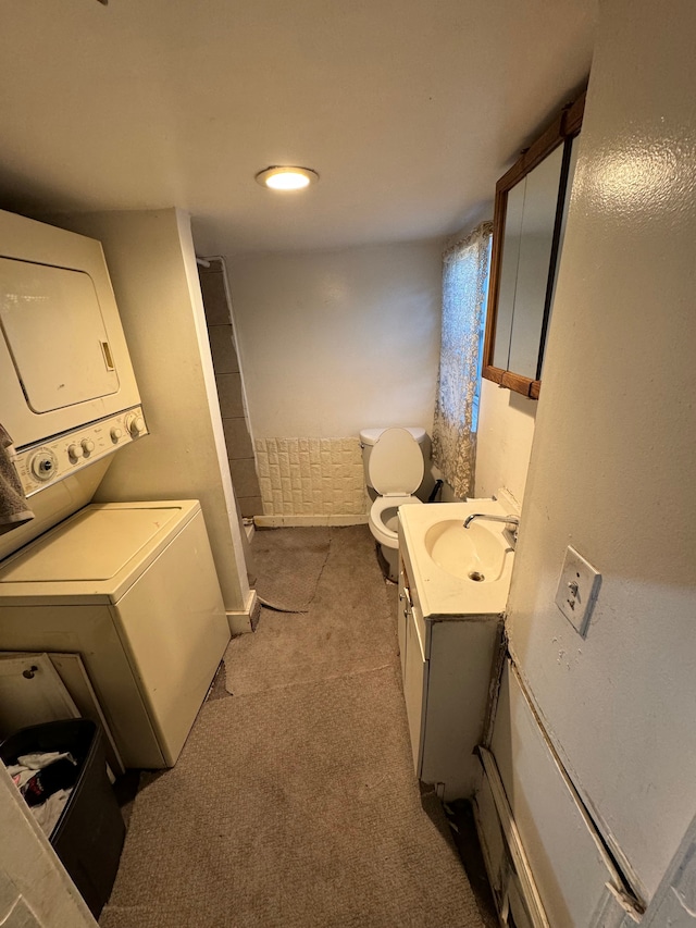 laundry area with laundry area, carpet floors, stacked washer / drying machine, and a sink