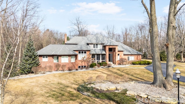 6579 Partridge Ln, Holland, MI 49423 - prairie-style house featuring a chimney, a front lawn, and brick siding