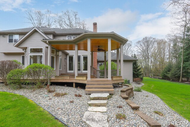 6579 Partridge Ln, Holland, MI 49423 - rear view of property with a ceiling fan, a chimney, a yard, and a wooden deck