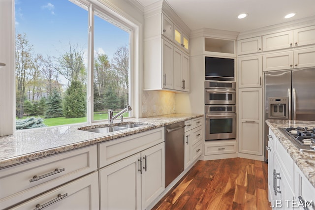 6579 Partridge Ln, Holland, MI 49423 - kitchen featuring appliances with stainless steel finishes, a sink, dark wood-style flooring, light stone counters, and recessed lighting