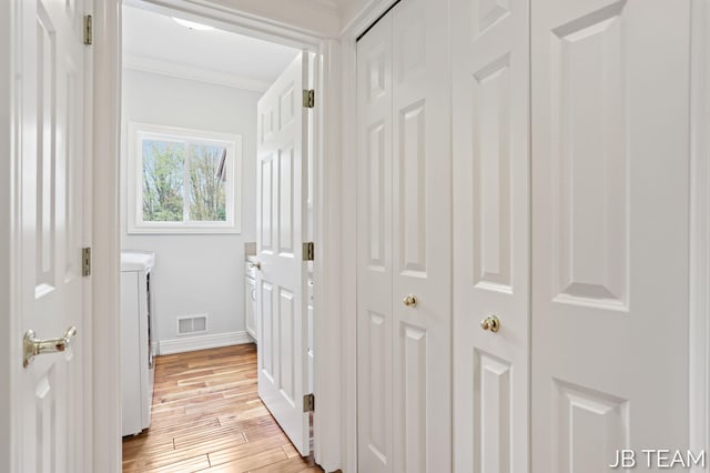 6579 Partridge Ln, Holland, MI 49423 - corridor with light wood-style flooring, baseboards, ornamental molding, and separate washer and dryer