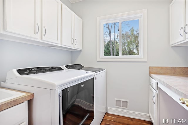 6579 Partridge Ln, Holland, MI 49423 - laundry area featuring cabinet space, washing machine and clothes dryer, baseboards, and dark wood-style floors