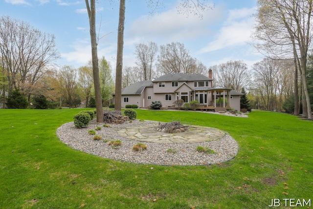 6579 Partridge Ln, Holland, MI 49423 - back of house featuring a fire pit, a chimney, a wooden deck, and a yard