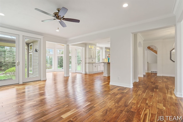 6579 Partridge Ln, Holland, MI 49423 - unfurnished living room featuring ornamental molding, wood finished floors, arched walkways, ceiling fan, and baseboards