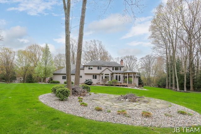 6579 Partridge Ln, Holland, MI 49423 - rear view of house with a fire pit, a chimney, a deck, and a lawn