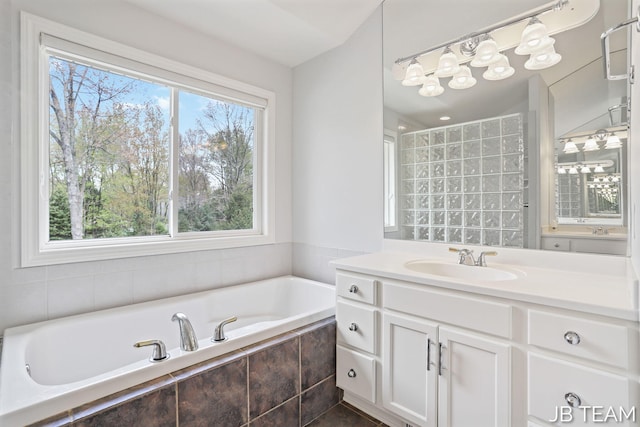 6579 Partridge Ln, Holland, MI 49423 - bathroom with healthy amount of natural light, a bath, a chandelier, and vanity
