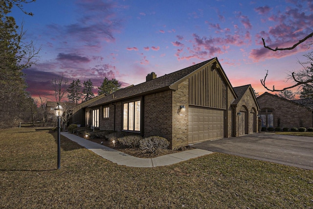 23930 Greenglen Ct, Franklin, MI 48025 - view of side of property featuring brick siding, a chimney, a garage, aphalt driveway, and board and batten siding