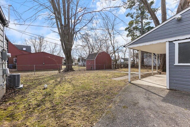 view of yard featuring a patio area, cooling unit, an outdoor structure, and fence