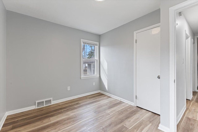 spare room featuring visible vents, baseboards, and light wood-style floors