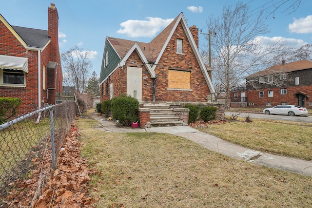 tudor house with a front lawn and fence