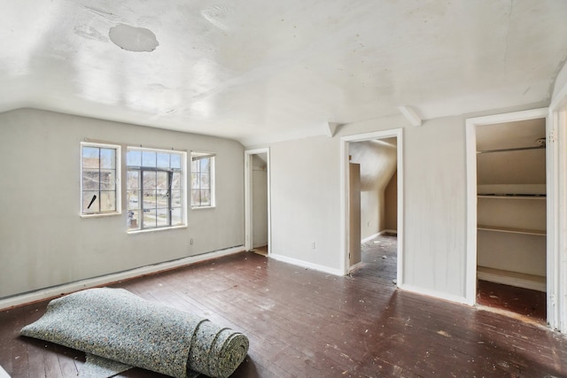 living room with baseboards, hardwood / wood-style floors, and vaulted ceiling