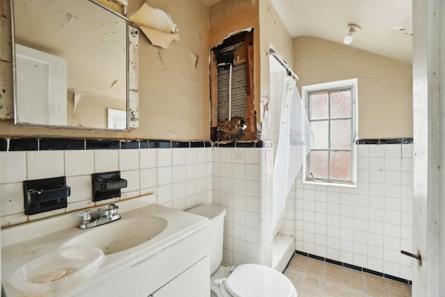 bathroom with a shower with curtain, toilet, tile walls, tile patterned flooring, and vanity