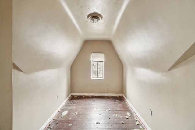 additional living space with lofted ceiling, hardwood / wood-style flooring, and baseboards