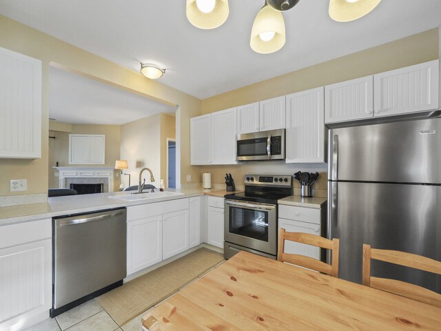 kitchen with white cabinetry, light tile patterned floors, appliances with stainless steel finishes, and a sink