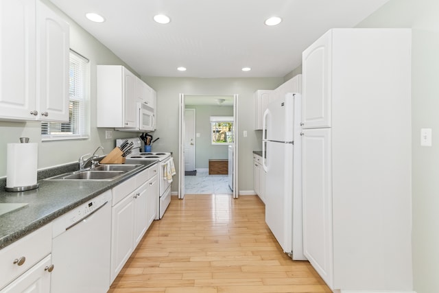 537 Andresen Ct, Hazel Park, MI 48030 - kitchen featuring white appliances, a sink, light wood-type flooring, white cabinetry, and dark countertops