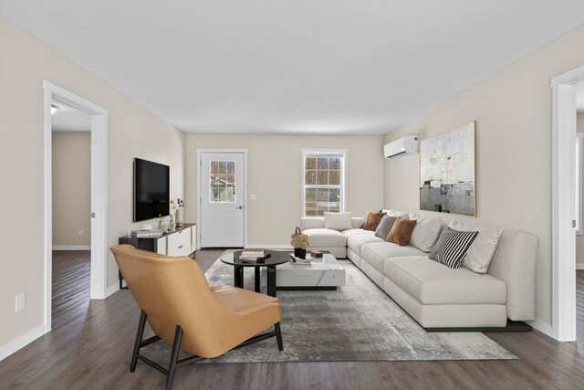 living room featuring baseboards, wood finished floors, and a wall unit AC