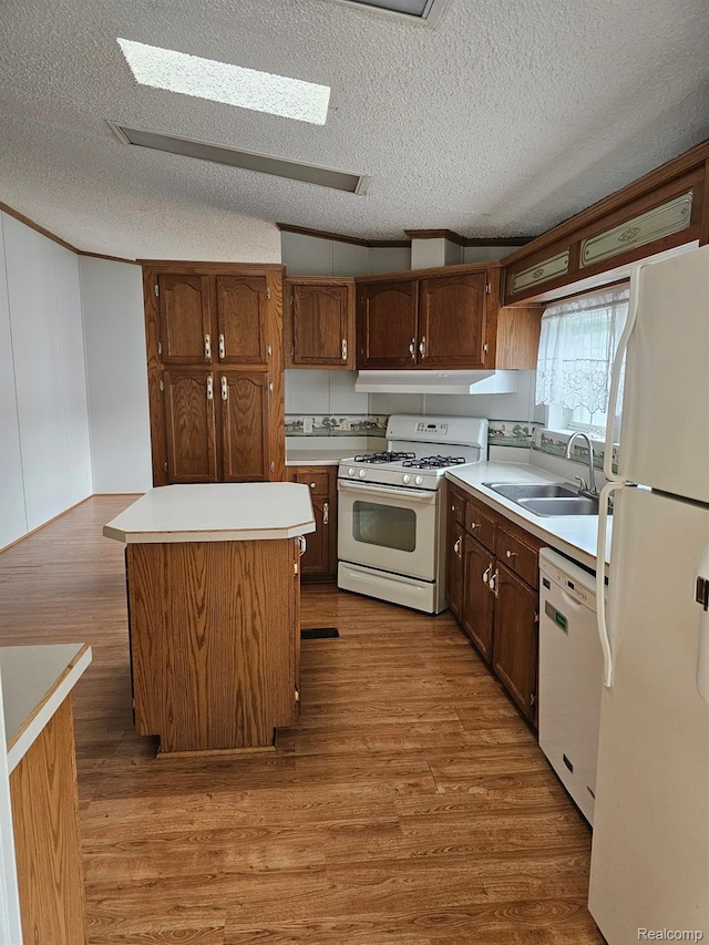 73 Grey Fox Ct, Grand Blanc, MI 48439 - kitchen with white appliances, wood finished floors, light countertops, a textured ceiling, and a kitchen island