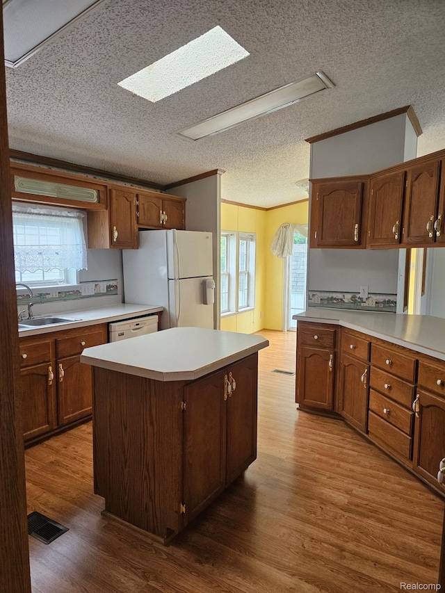 73 Grey Fox Ct, Grand Blanc, MI 48439 - kitchen with white appliances, a textured ceiling, dark wood-style flooring, light countertops, and a kitchen island