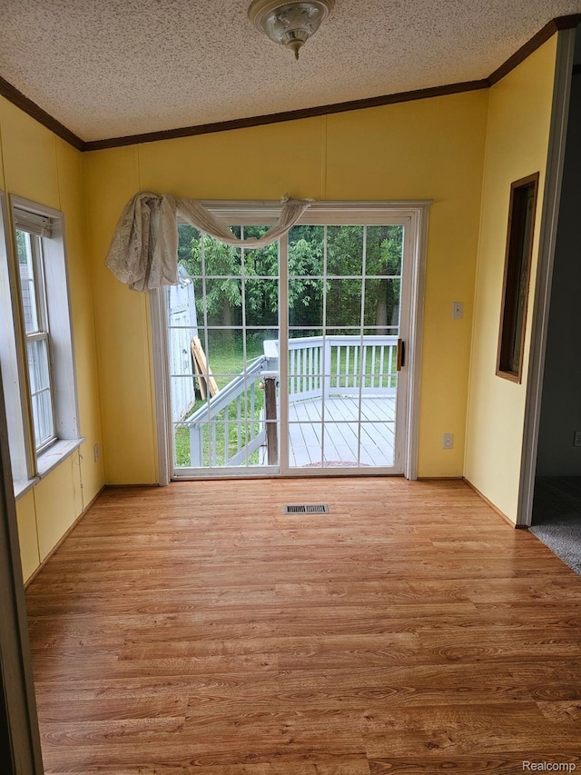 73 Grey Fox Ct, Grand Blanc, MI 48439 - unfurnished dining area with ornamental molding, a textured ceiling, and wood finished floors