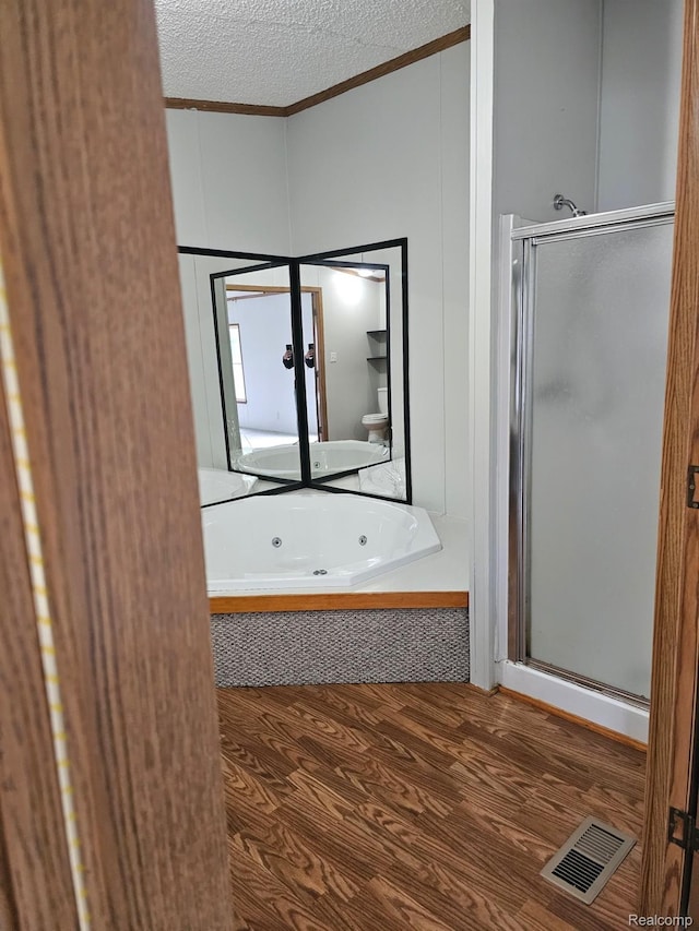 73 Grey Fox Ct, Grand Blanc, MI 48439 - bathroom featuring ornamental molding, wood finished floors, a stall shower, a jetted tub, and a textured ceiling