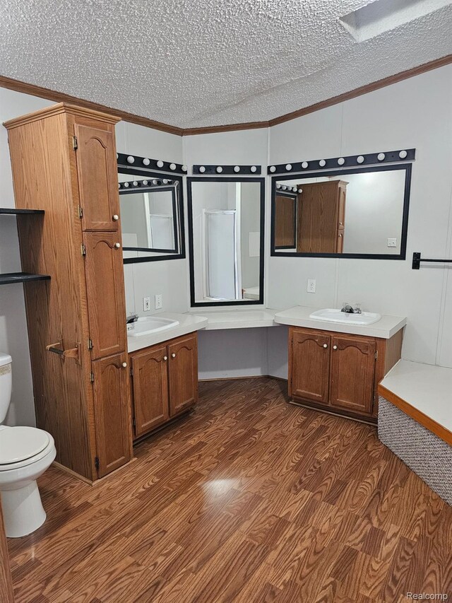 73 Grey Fox Ct, Grand Blanc, MI 48439 - bathroom featuring crown molding, a textured ceiling, wood finished floors, and two vanities