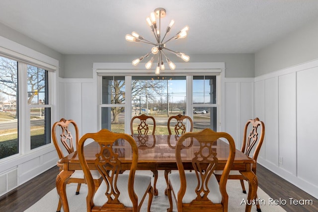 dining room featuring visible vents, an inviting chandelier, dark wood finished floors, and a decorative wall