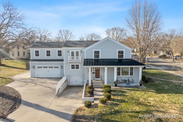 traditional-style house with a standing seam roof, concrete driveway, a front yard, an attached garage, and metal roof