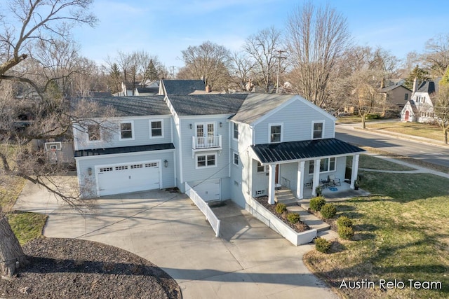 view of front of home featuring a porch, concrete driveway, a front yard, an attached garage, and a balcony