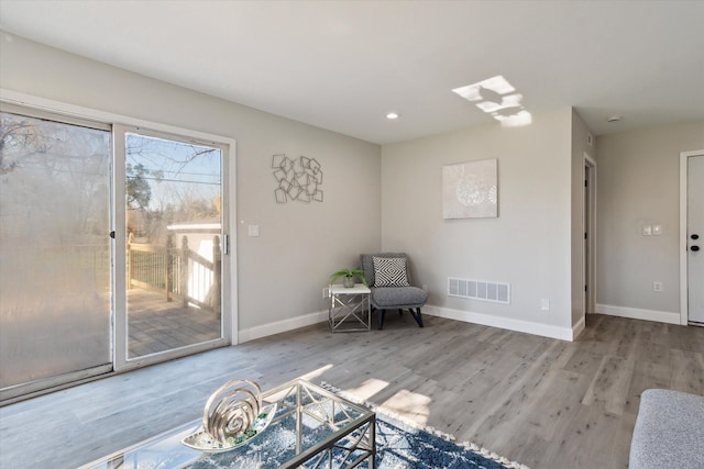 unfurnished room with wood finished floors, baseboards, and visible vents
