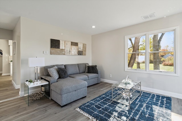 living area featuring visible vents, recessed lighting, wood finished floors, and baseboards