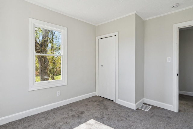 unfurnished bedroom with crown molding, multiple windows, carpet flooring, and baseboards