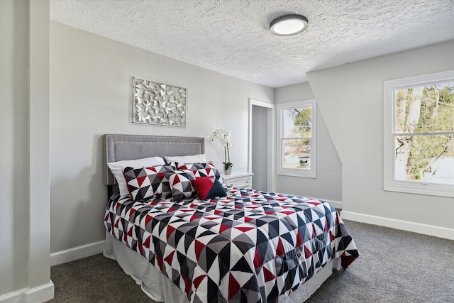 bedroom with dark carpet, a textured ceiling, and baseboards