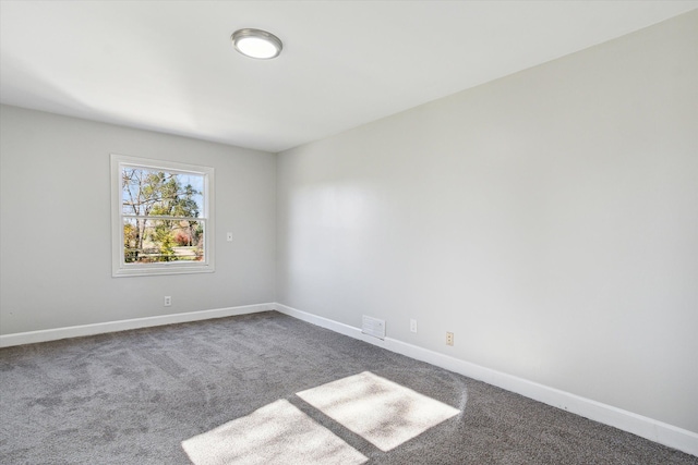 carpeted empty room featuring visible vents and baseboards