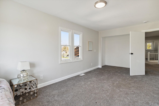 unfurnished bedroom featuring visible vents, carpet floors, and baseboards