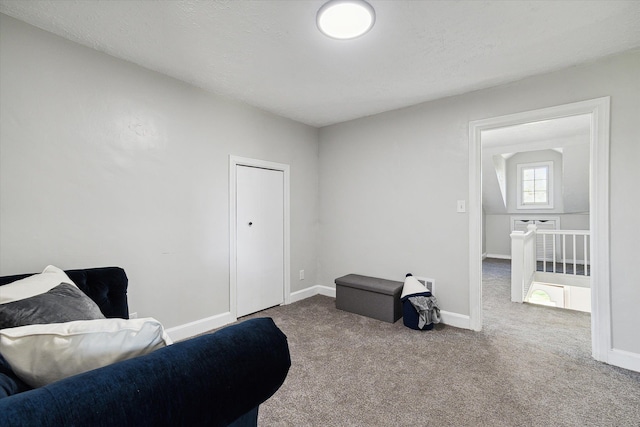sitting room featuring carpet flooring, baseboards, and a textured ceiling
