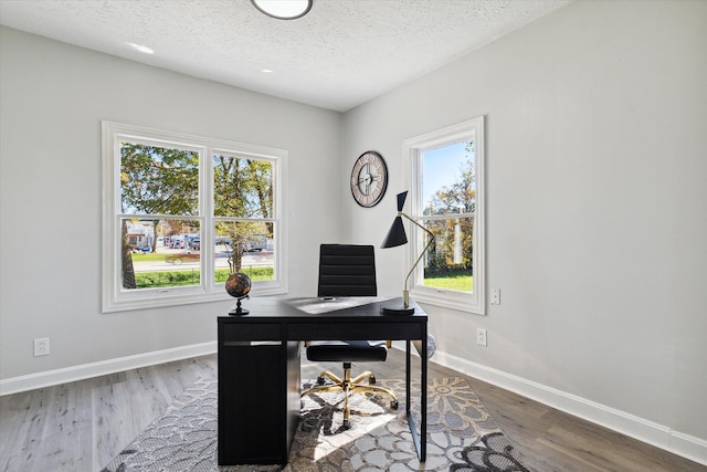 office with baseboards, a textured ceiling, and wood finished floors