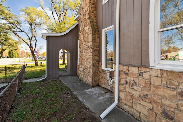 doorway to property with fence and stone siding