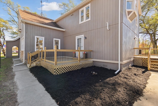 rear view of house featuring crawl space, a deck, and a shingled roof