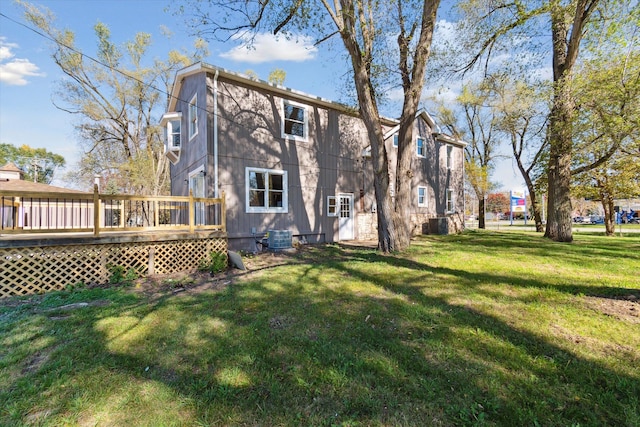rear view of property with central AC, a wooden deck, and a yard